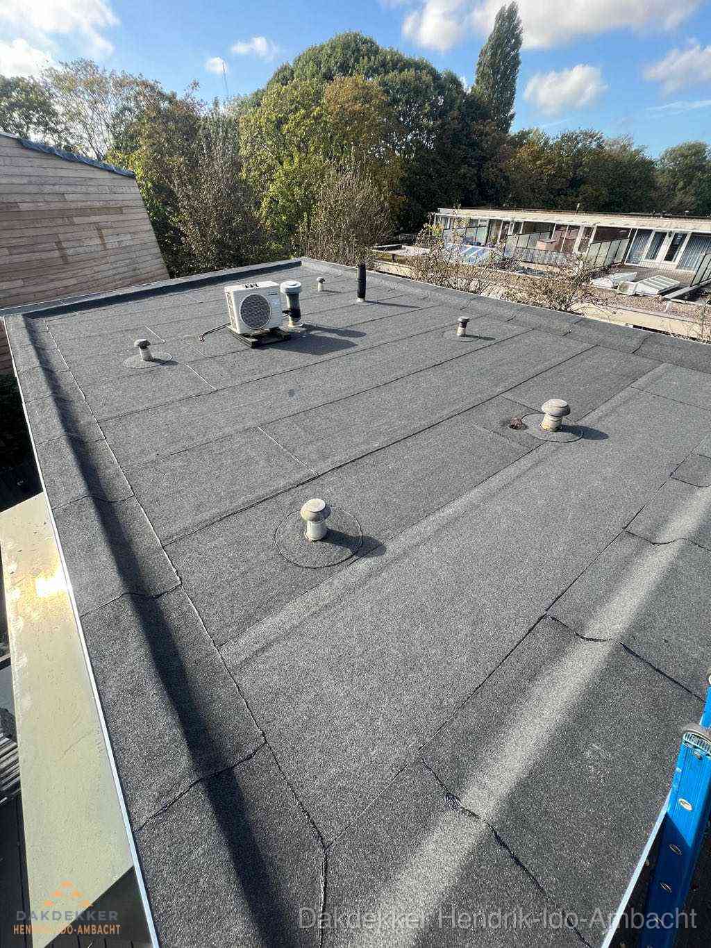 Plat dak met bitumen en brandgereedschap van dakdekkersbedrijf in Hendrik-Ido-Ambacht